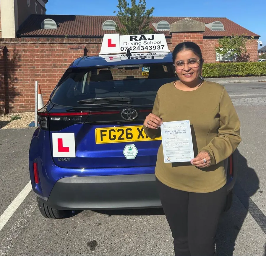 A student holding their driving test pass certificate beside Raj's Toyota Yaris Cross