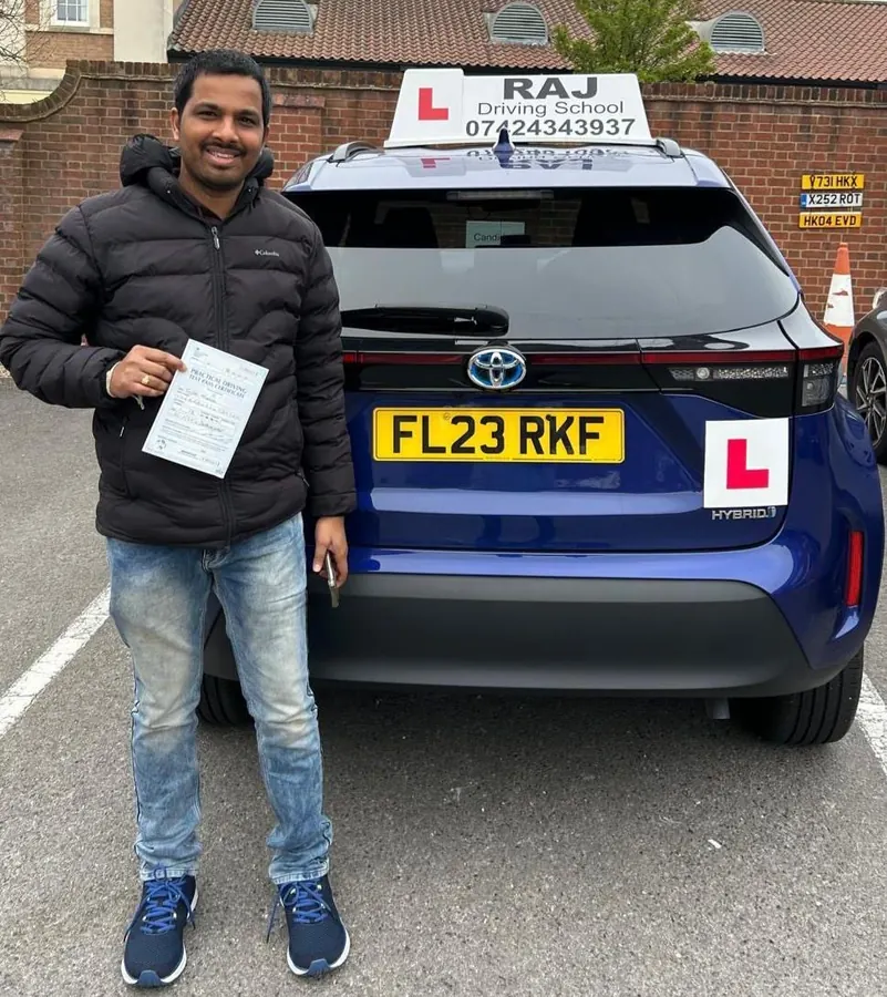 A student holding their driving test pass certificate beside Raj's Toyota Yaris Cross