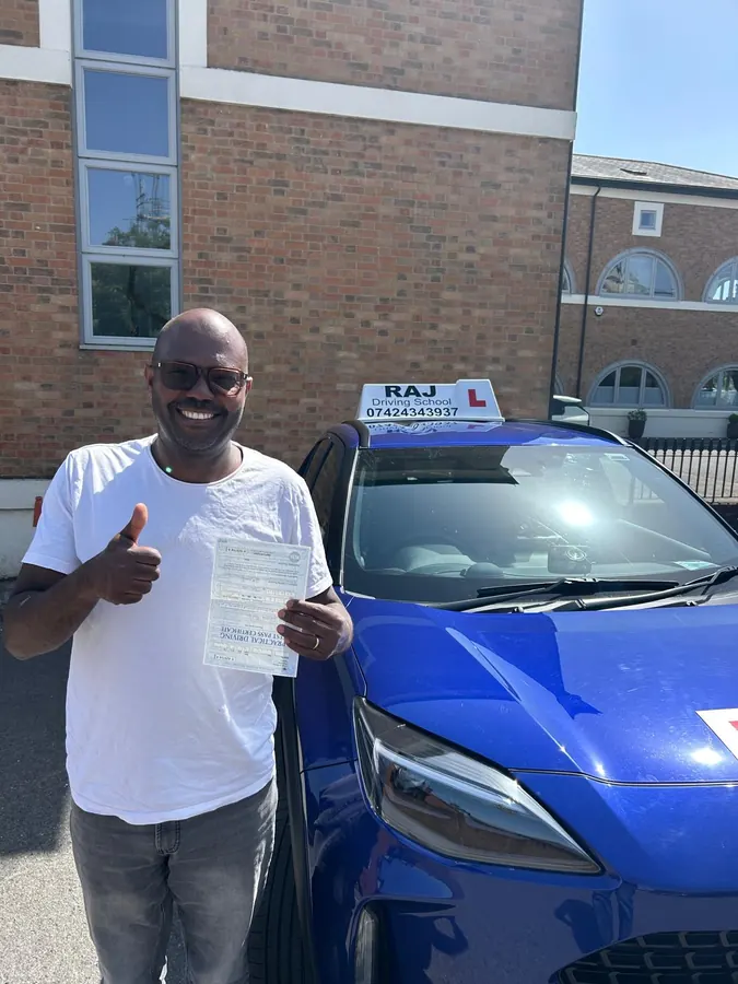A student holding their driving test pass certificate beside Raj's Toyota Yaris Cross