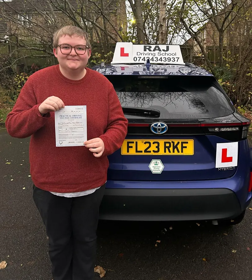 A student holding their driving test pass certificate beside Raj's Toyota Yaris Cross