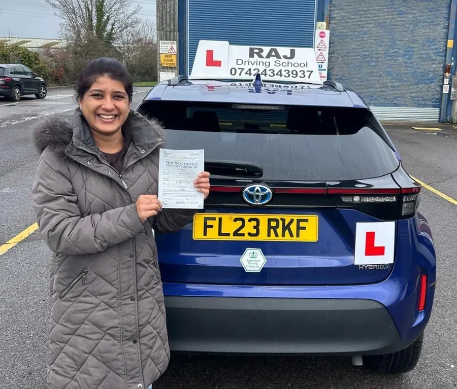 A student holding their driving test pass certificate beside Raj's Toyota Yaris Cross
